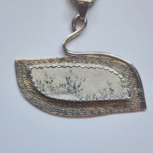 Jewelry with an oval-shaped white dendritic agate pendant.
